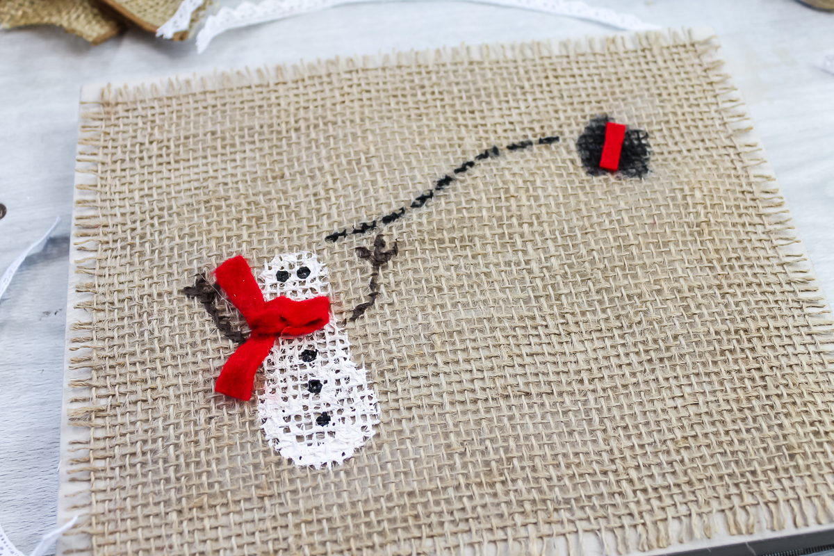 adding embellishments to winter snowman art