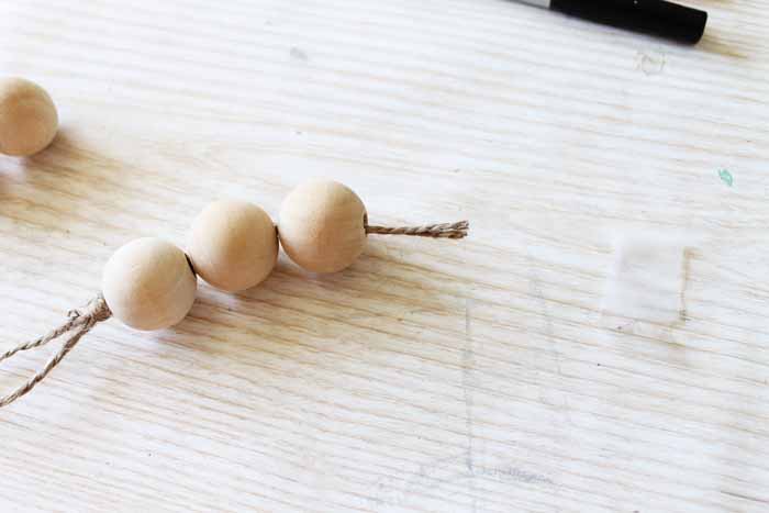 stringing wood beads on twine