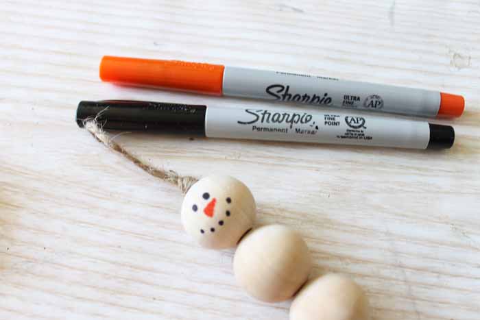 adding a snowman face with orange and black markers