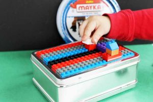 lego tape on a box and little boy playing with legos