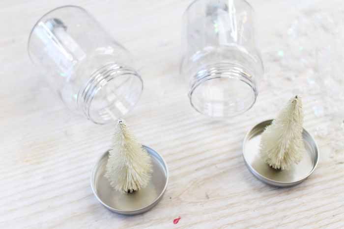 adding small fake trees to mason jar lids with glue