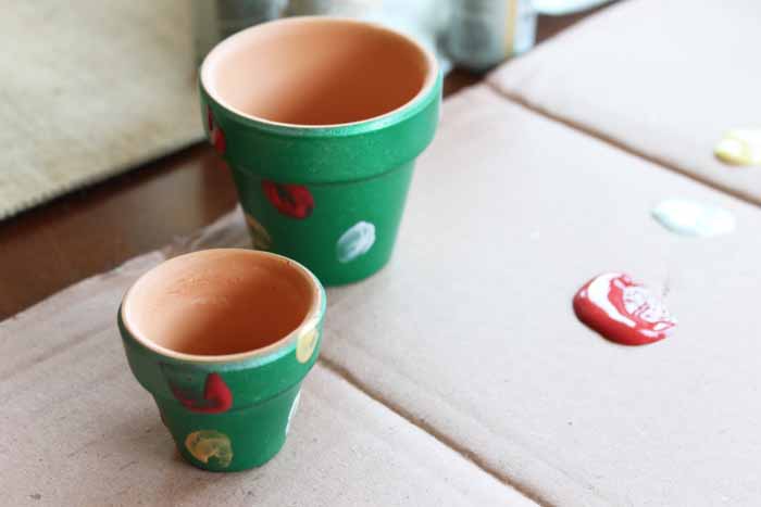green clay pots with different colored thumbprints