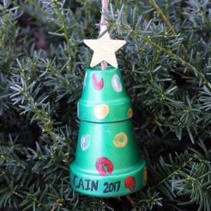thumbprint art on clay pots hanging on a christmas tree