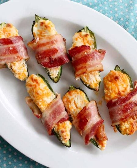 bacon wrapped stuffed jalapenos on a plate