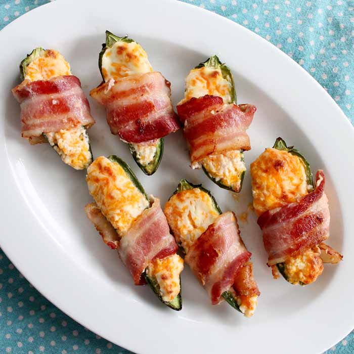 bacon wrapped stuffed jalapenos on a plate