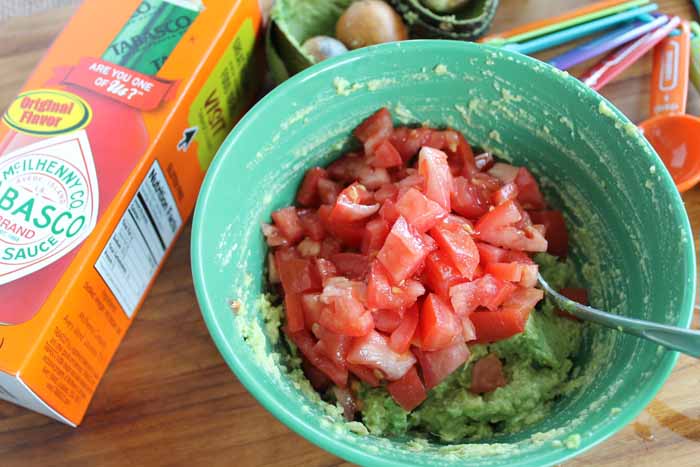 adding tomatoes to spread recipe