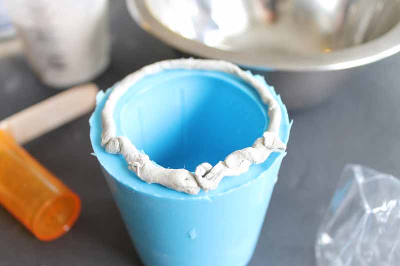 adding putty to the bottom of a mason jar mold