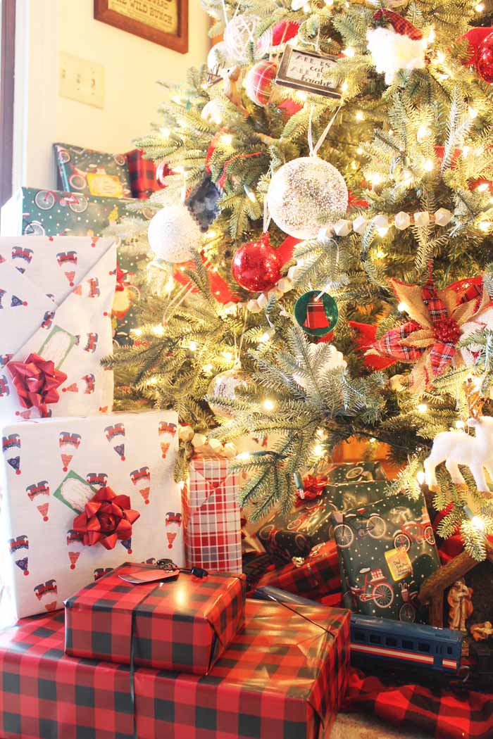 ornaments on a tree with wrapped presents