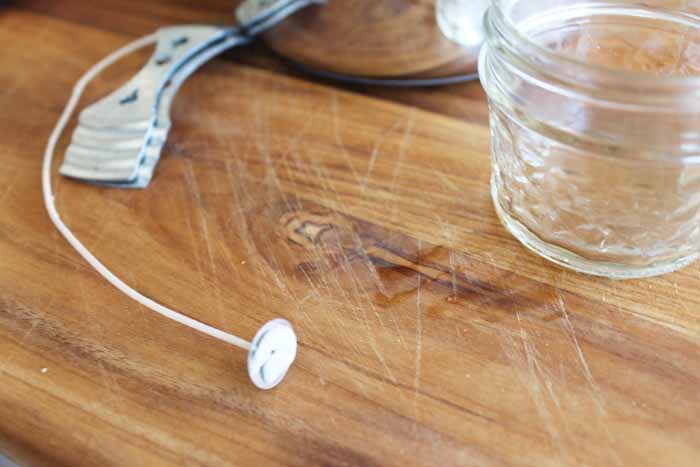 adding candle wick to the bottom of a mason jar