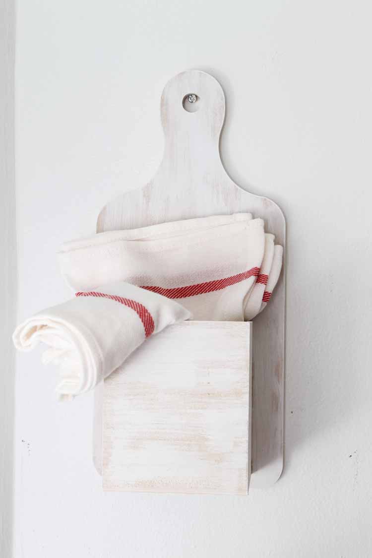 tea towels in a kitchen organizer hanging on a wall