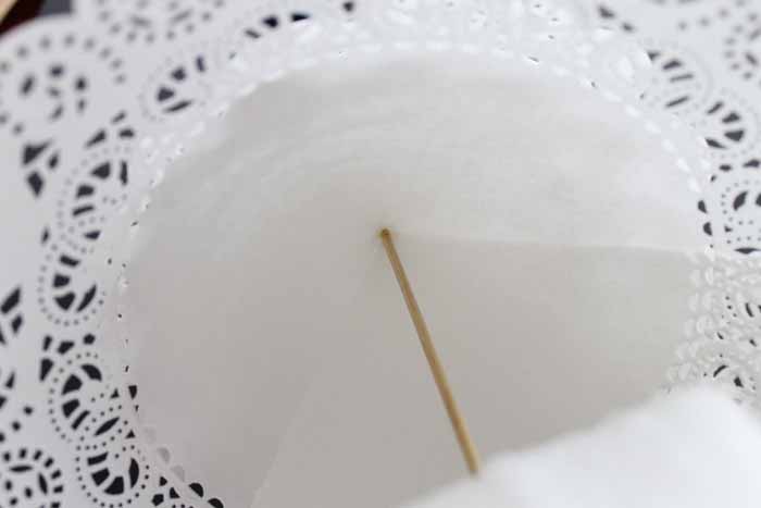 wood skewer pushed through the center of a doily