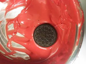 covering oreos in red coating chocolate