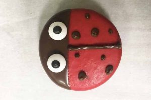 adding chocolate details to a ladybug cookie