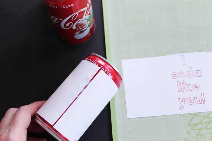 top shot of how to tape paper to soda can for cheesy valentines