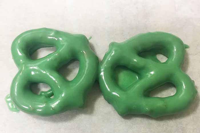 green chocolate covered pretzels on parchment paper
