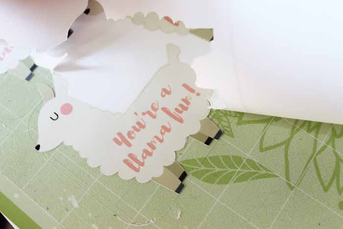 Cut-out white llama valentines on green craft mat