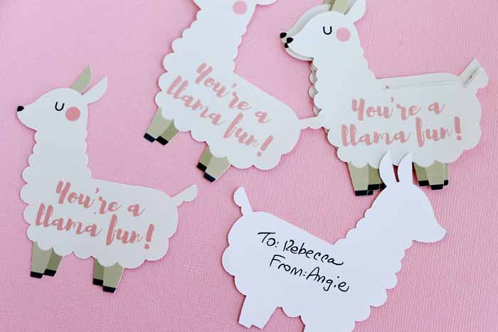 Cut-out white llama valentines on pink background