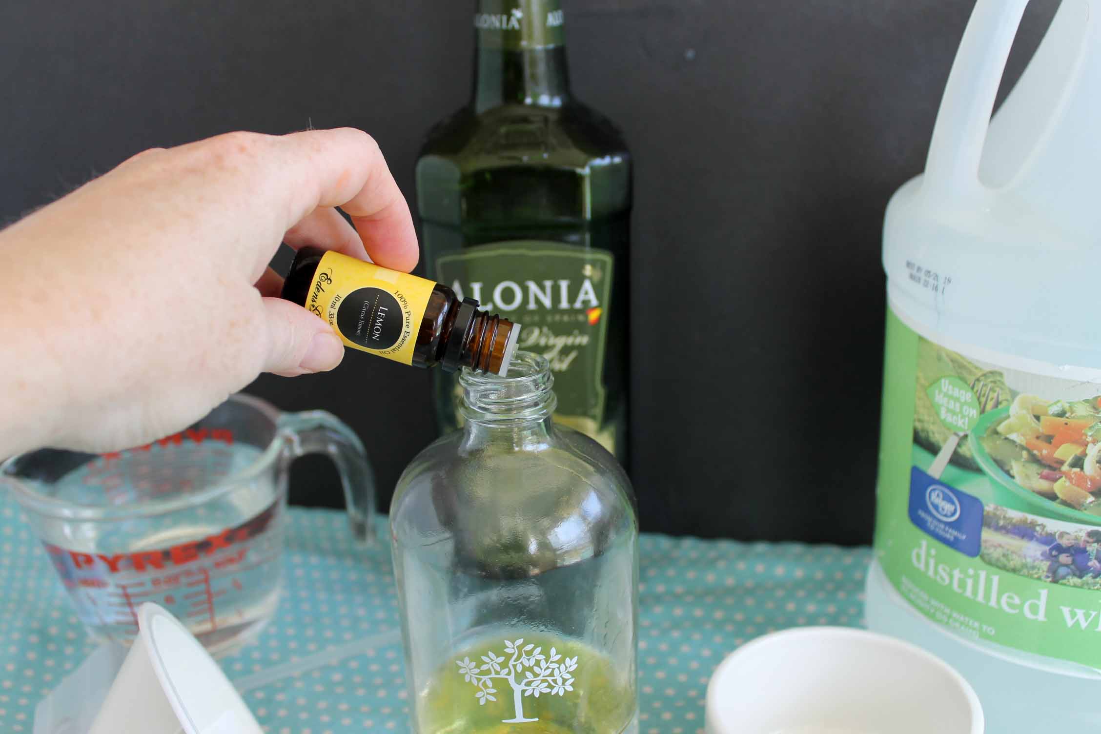 adding lemon essential oil to spray bottle