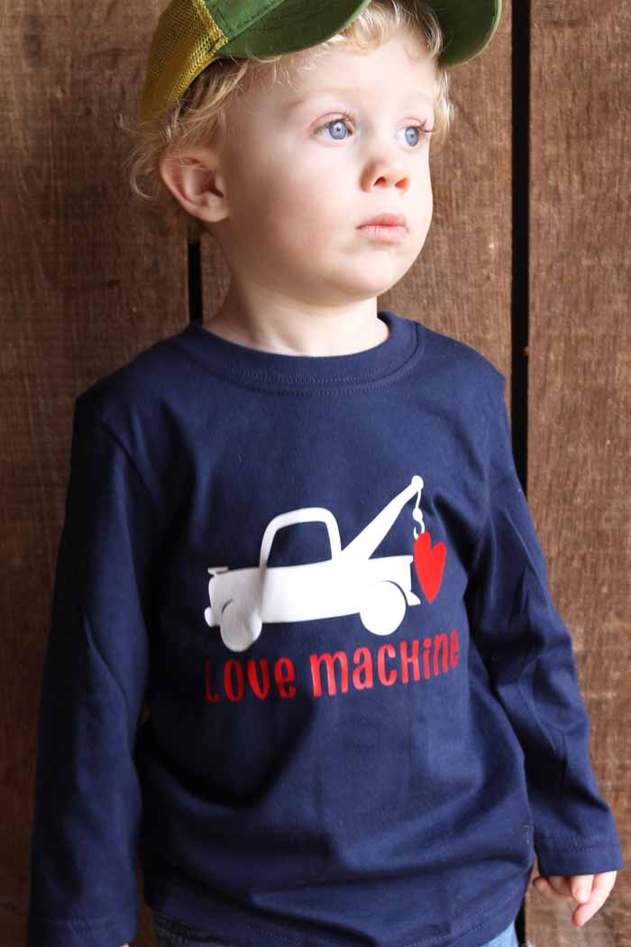 A little boy wearing a hat and a valentine shirt