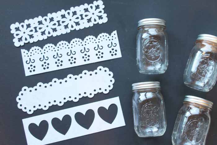 4 mason jars and 4 different white cut felt designs