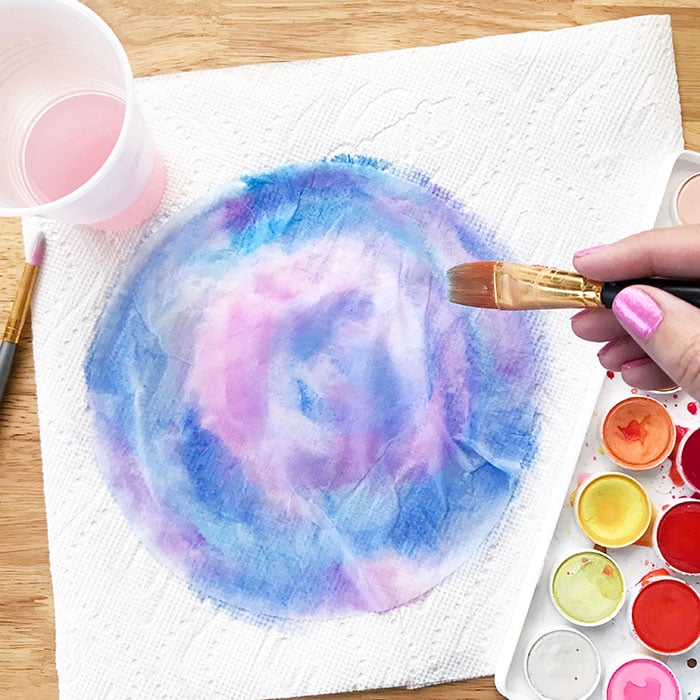 Painting tissue paper with blue and purple water color to make beautiful tissue paper flowers