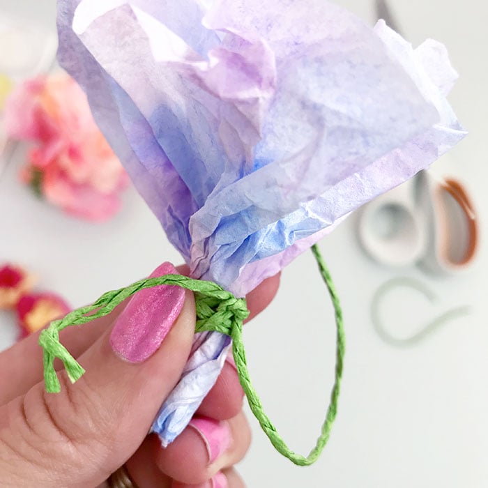 Tie twine or string around the stem of your tissue paper flower