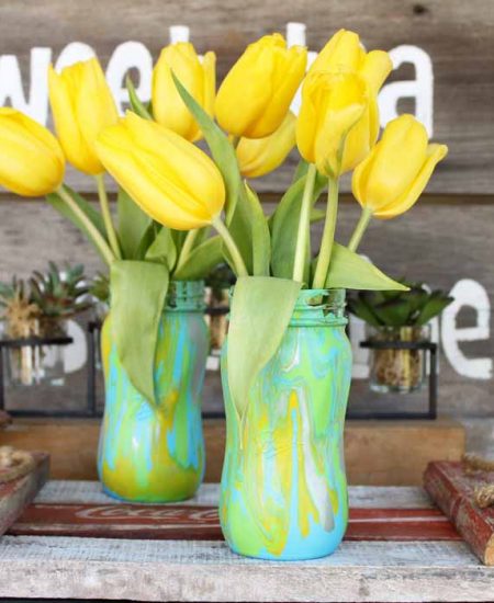 yellow flowers in mason jars that have marbled paint