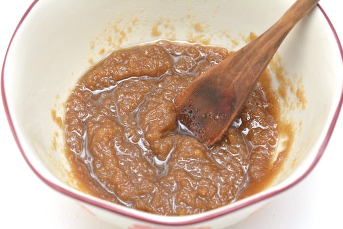 sugar scrub mixed in a bowl with a wood spoon
