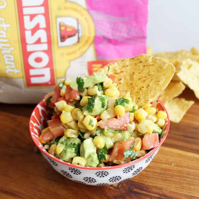 Make some sweet corn salsa with avocado! Serve this up for Cinco de Mayo with either chips or as a tasty topping for tacos! #recipe #cincodemayo #salsa #avocado