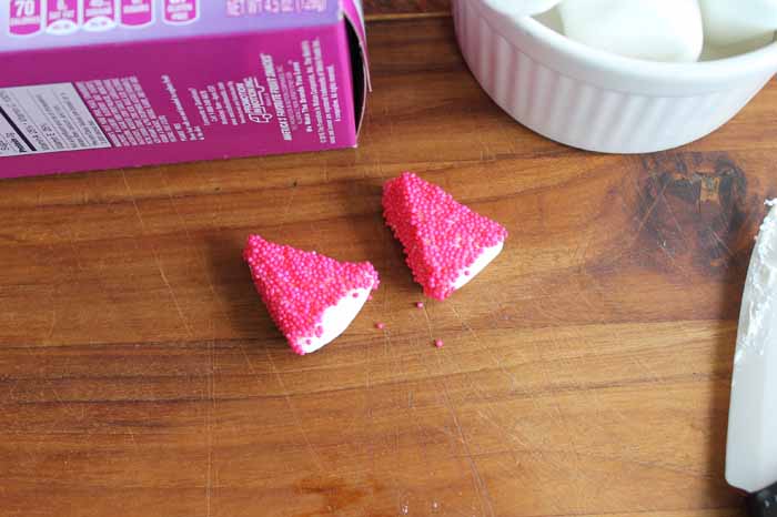 Cover the sticky sides of the marshmallows in sprinkles to make the unicorn ears