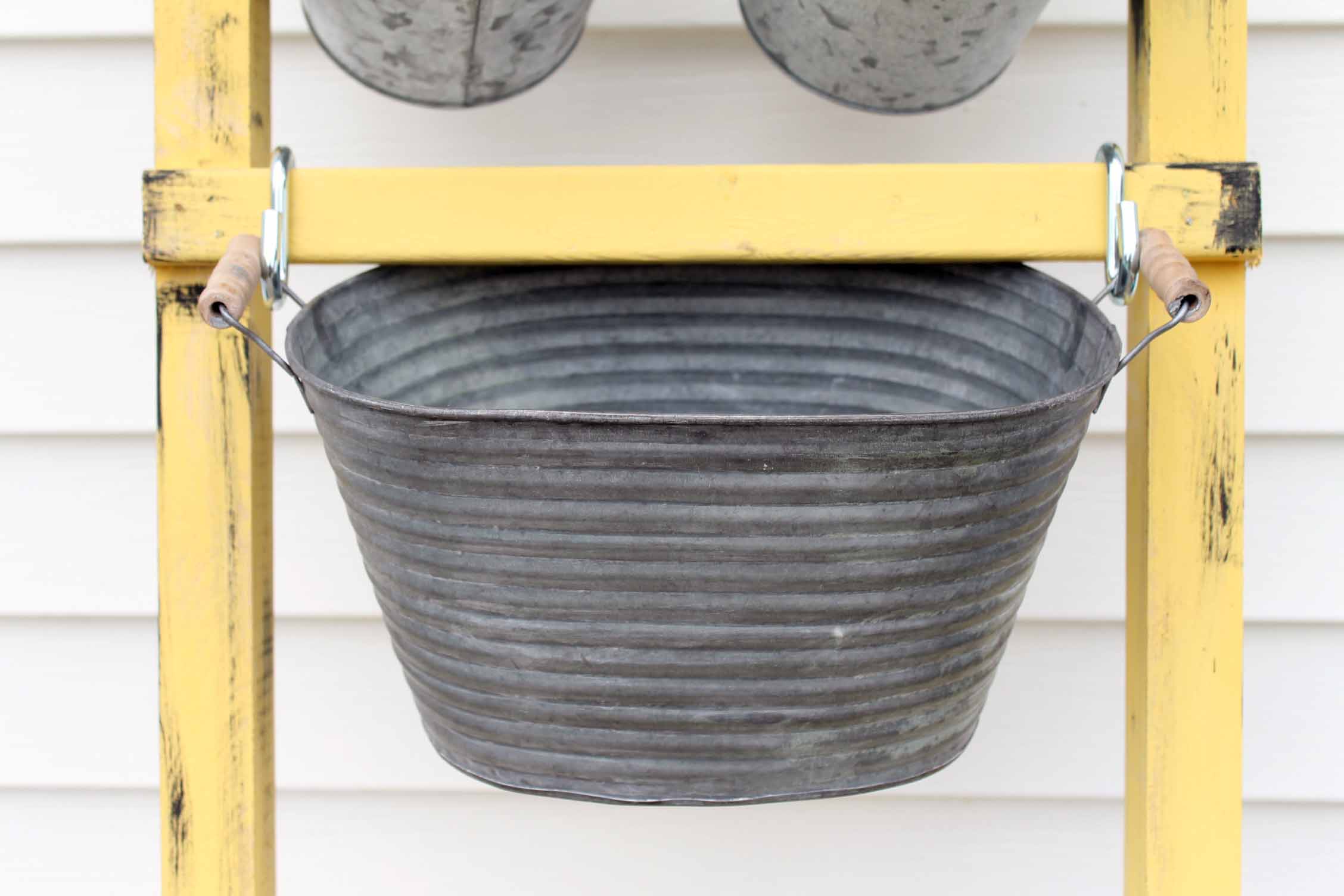 galvanized tub hanging on a ladder