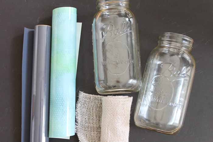 quart mason jars, burlap ribbon, and heat transfer vinyl on a table