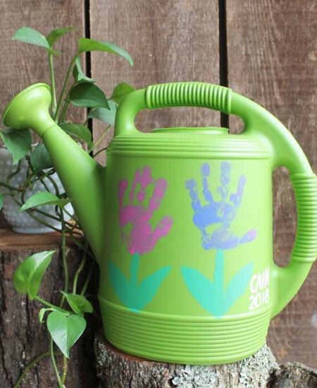 handprint flowers watering can on a stump