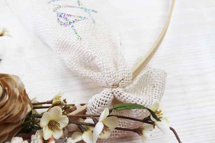 securing burlap ribbon into place on embroidery hoop