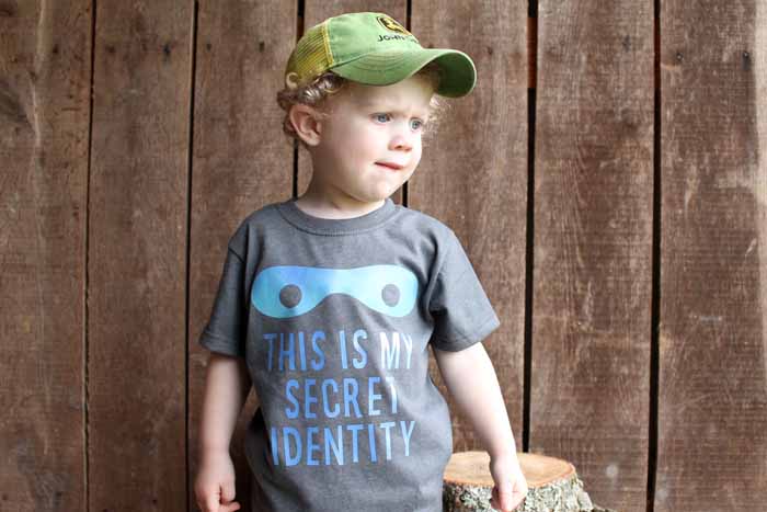 A little boy wearing a hat and an finished super hero iron on shirt