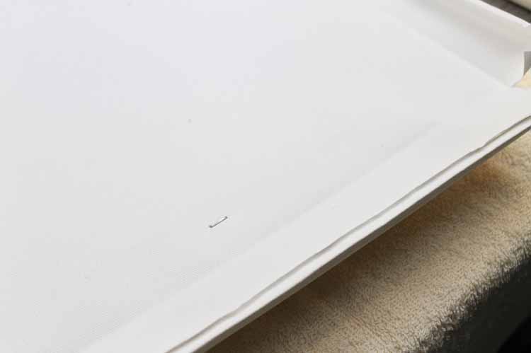Stapling your DIY canvas art to finish a reverse canvas.
