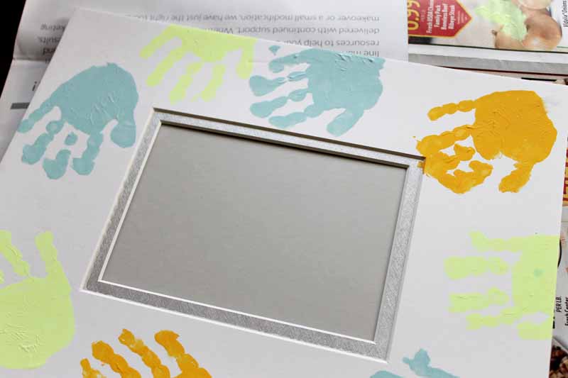 painted handprints on a picture frame mat