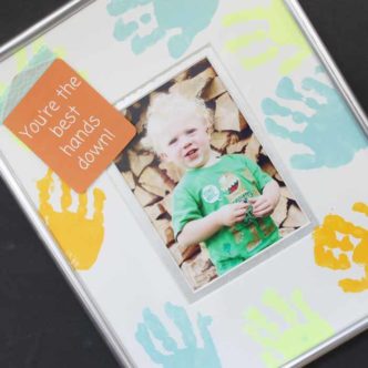 Add some handprint painting to a photo mat for a fun picture frame that dad will love this Father's Day! A quick and easy gift idea that toddlers and even babies can help make!