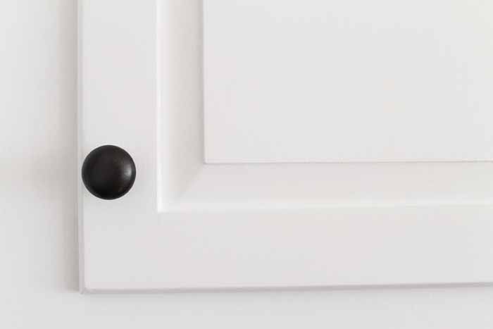 black knob on white cabinet