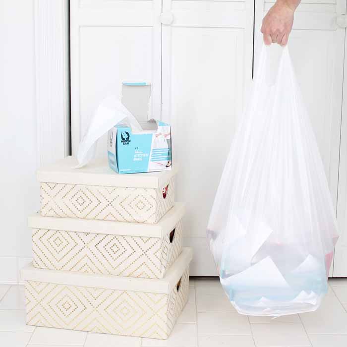 Three organizational boxes near trash bag of clutter