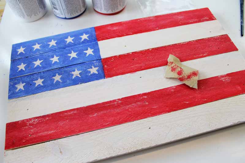 A rustic pallet flag being painted.