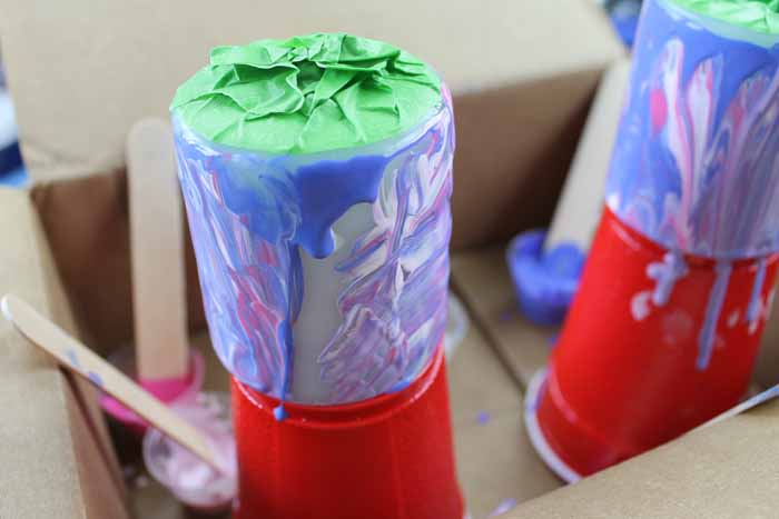 putting candle on a disposable cup for the paint to drip