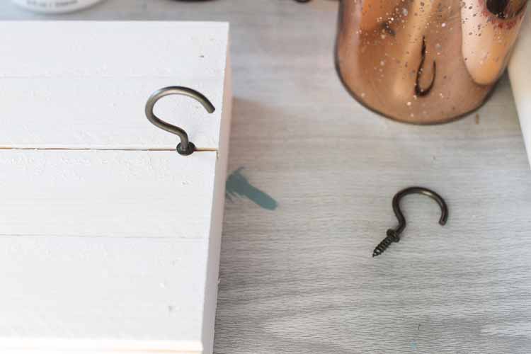 adding cup hooks to a rustic wood sign