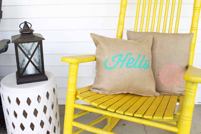 stenciled burlap pillows on a yellow rocking chair