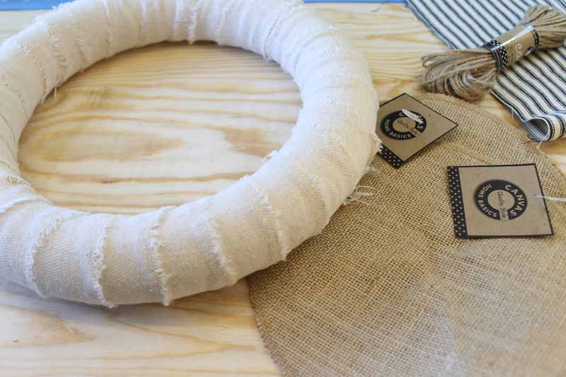 Wrapping ripped fabric strips around a wreath form.