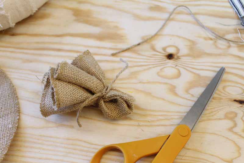 Gathering burlap circles to make burlap flowers for a wreath.