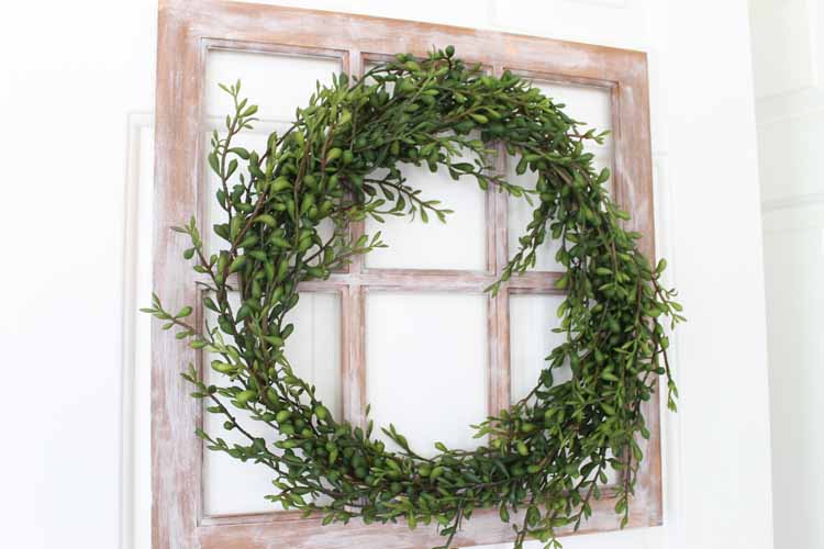 a green wreath on a rustic window