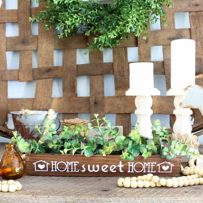 This wooden box centerpiece is perfect for your farmhouse style home! Make it in minutes with iron-on vinyl and your Cricut machine!