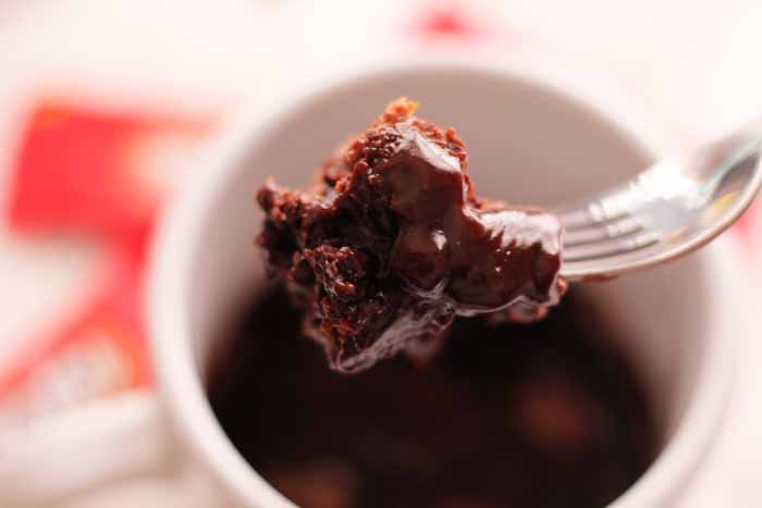 A close up of a bite of mug cake made with kit kat bars 