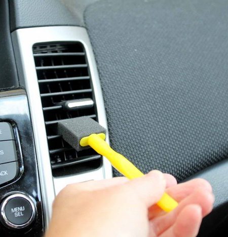 using a foam brush to detail a car